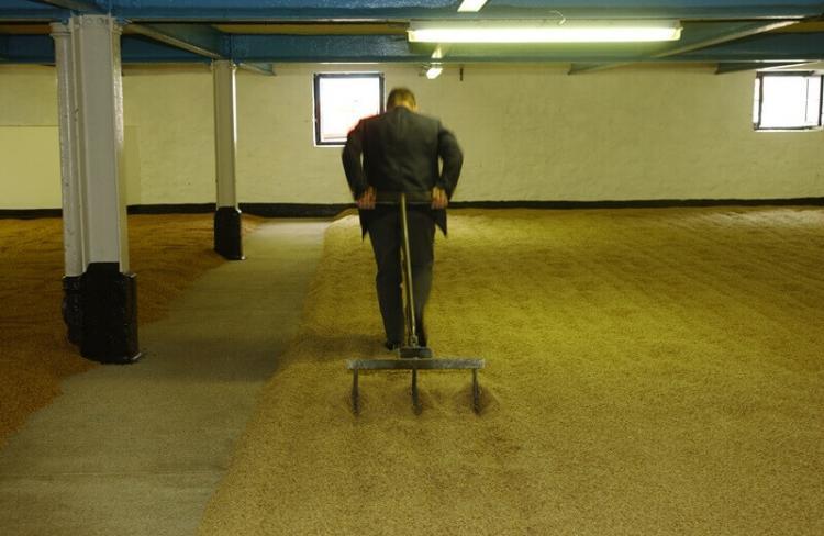 ▲2002年当時のマクファーソン蒸溜所長がみずからフロアモルティングの作業をやって見せてくれた。彼もアイラ島の出身だ