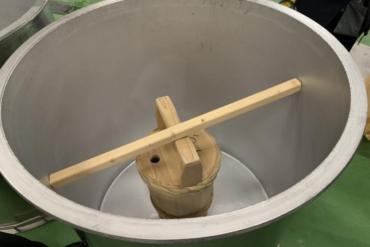 暖気樽はタンクに貯めた酛の中に深く沈めて、浮かないように渡した棒で抑えて温める